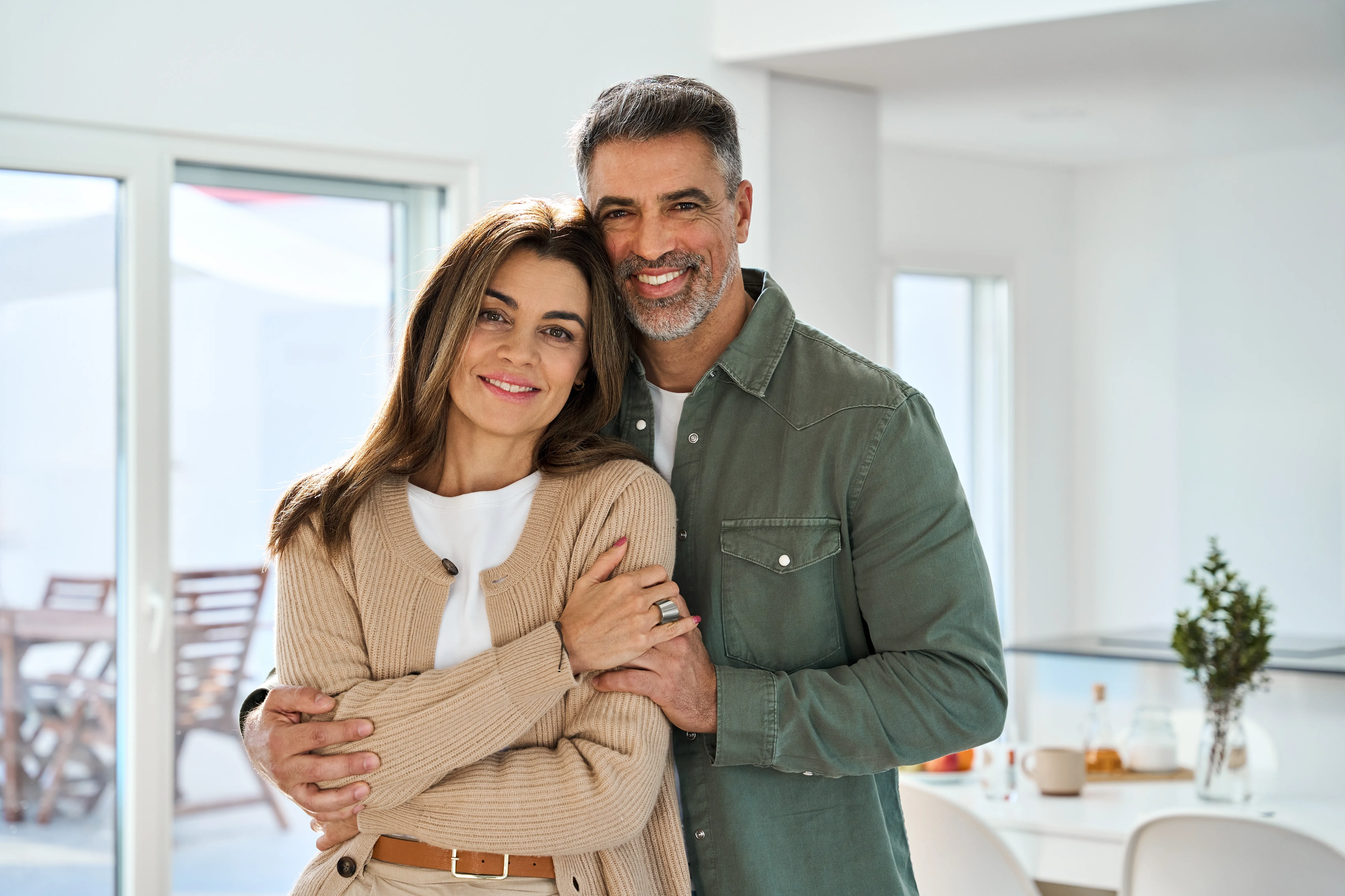 A smiling couple standing together at home